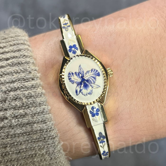 JAM TANGAN ANDRE MOUCHE PEEK-A-BOO IVORY BANGLE G0LD TONE BLUE FLORAL ENAMEL (LX2528)